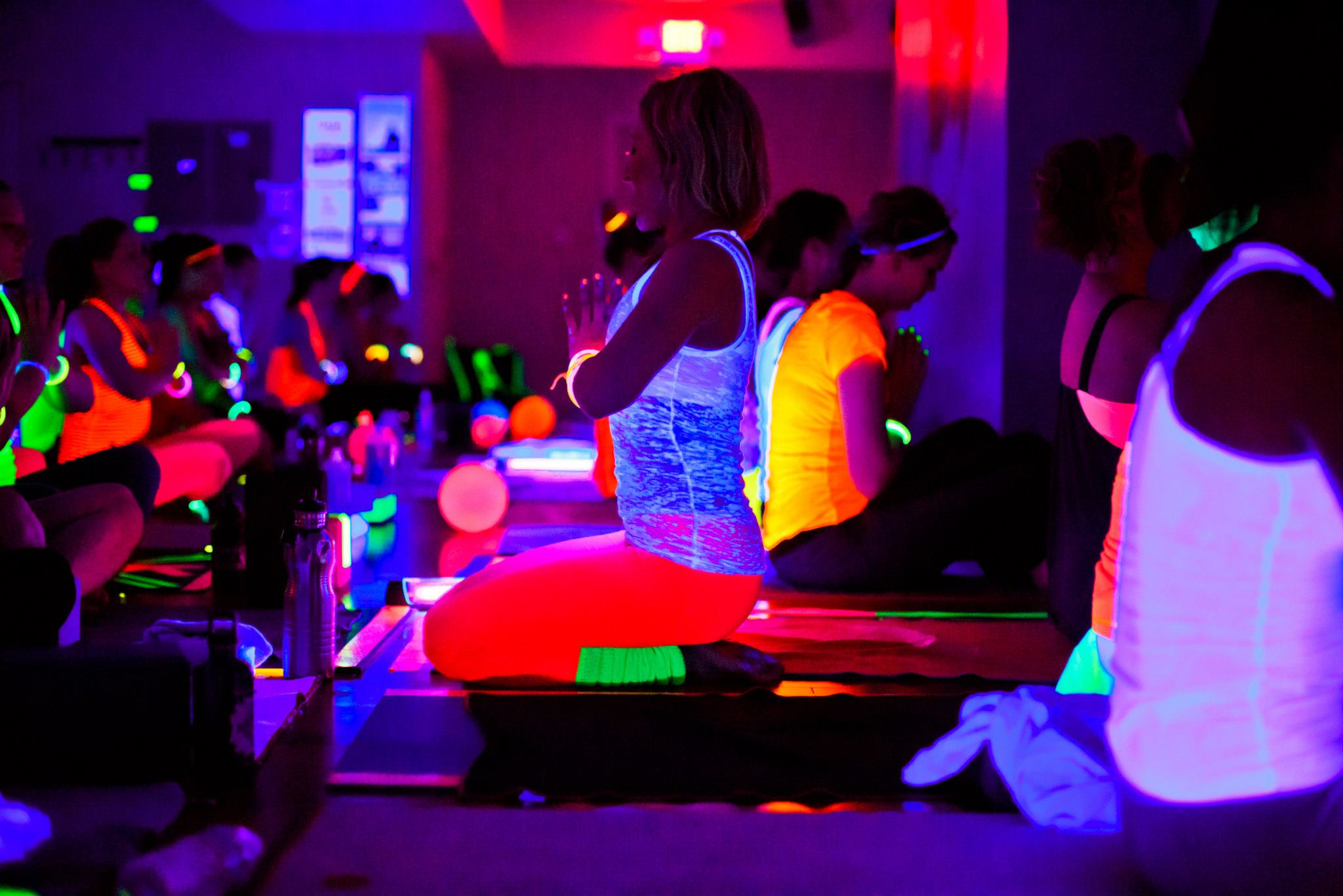 Yoga Instructor Leading Yoga Class in Dark Class with Glow in the Dark Clothing